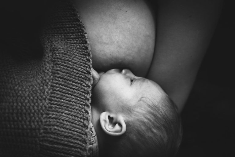 Un bébé est en train de téter le sein de sa maman pendant l'allaitement